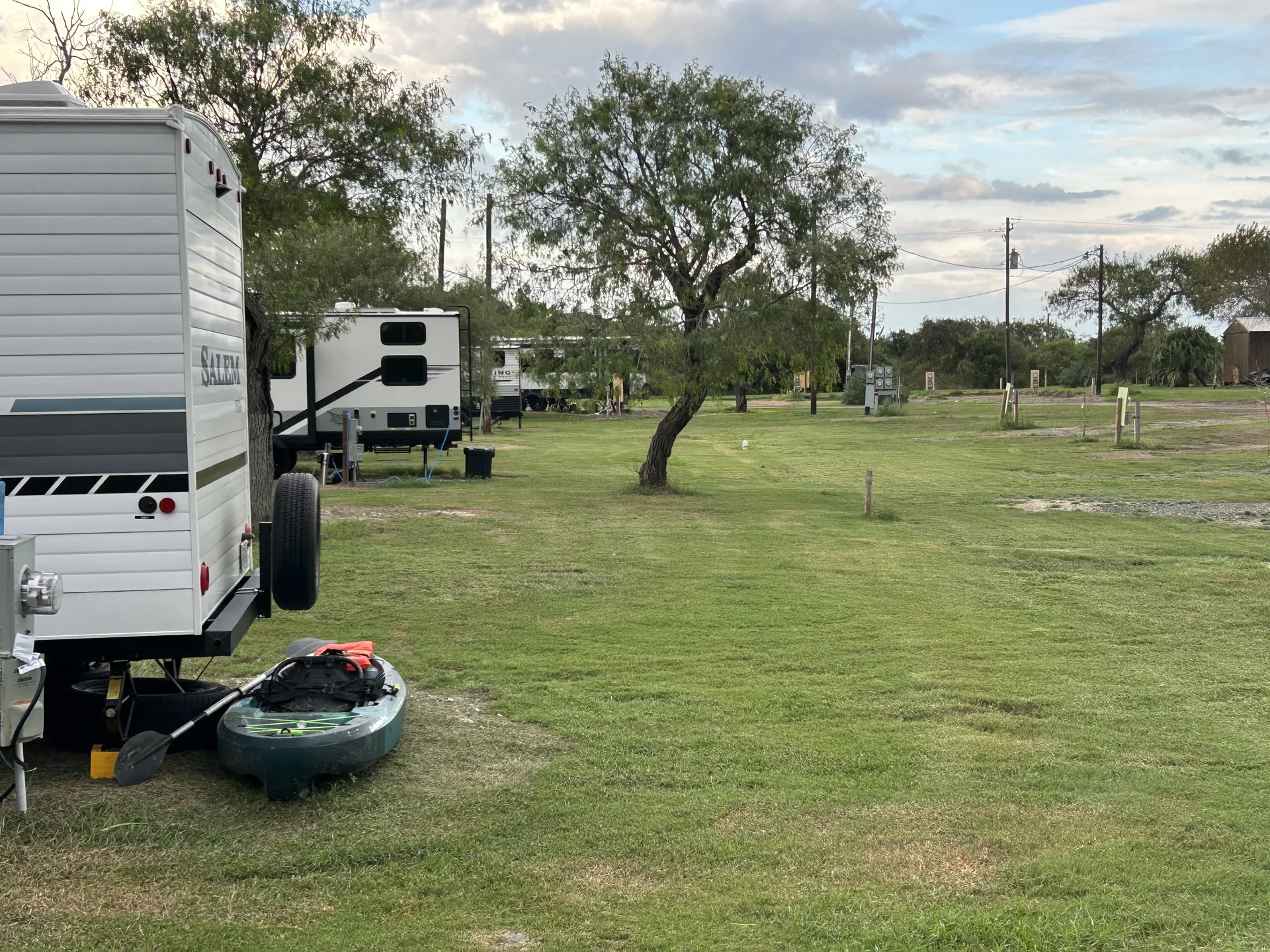 Guest RV sites with green lawns and mature trees at Down By The Bay RV Resort